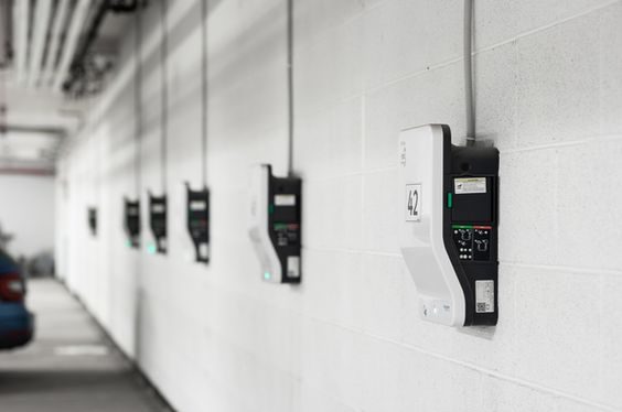 Entreprise de rénovation et d'énergies Calvados - Technicien installant une borne de recharge pour véhicules électriques.