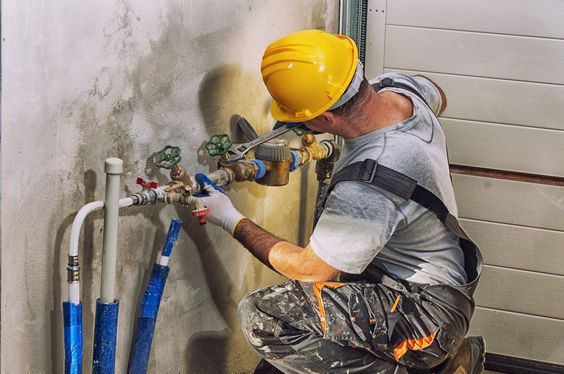 Entreprise de rénovation et d'énergies Calvados - Plombier installant des tuyaux.