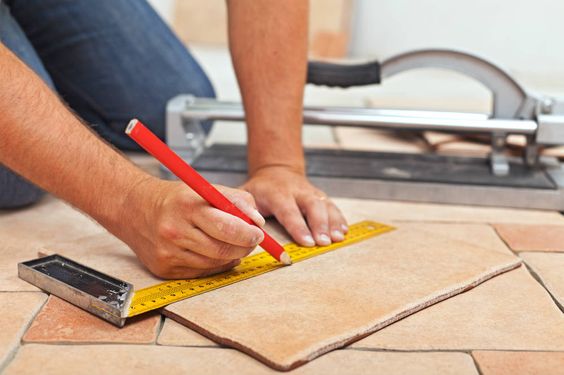Carreleur posant du carrelage dans une pièce pour une finition soignée et durable